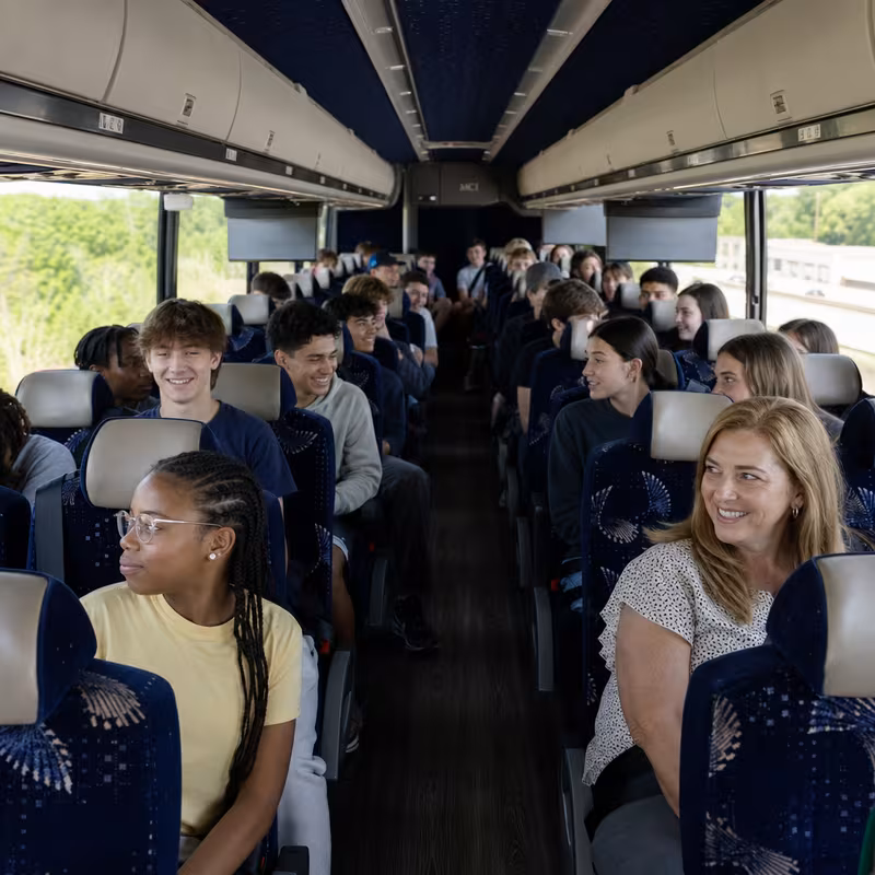 Group boarding a white charter bus for School Transportation transportation in Pasadena
