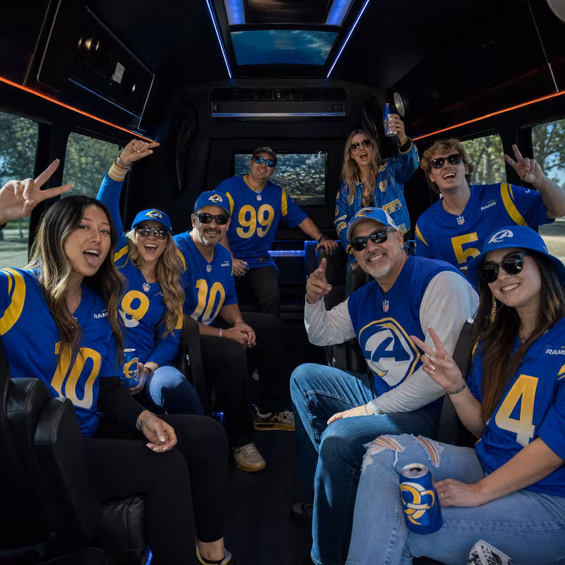 Group boarding a white charter bus for Sporting Event Transportation transportation in Pasadena