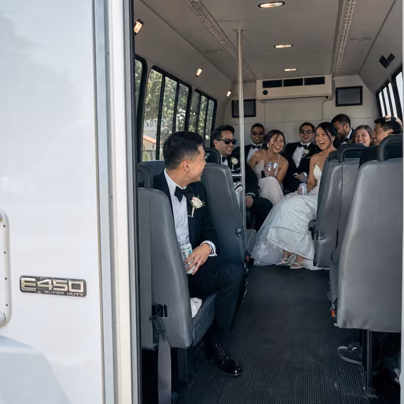 Group boarding a white charter bus for Wedding Transportation transportation in Pasadena